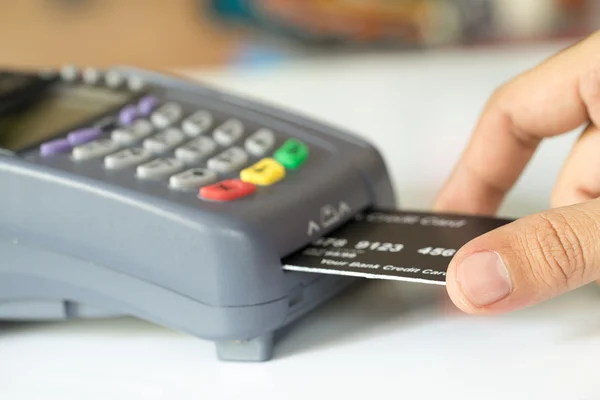 Cartão de crédito da mão em uma máquina do cartão de crédito: Foc seletivo — Fotografia de Stock