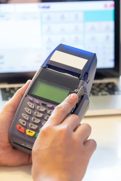 Mão com cartão de crédito deslize através do terminal para venda na loja — Fotografia de Stock