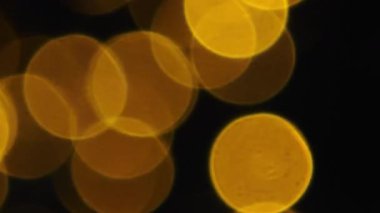 Ilık sarı, turuncu, kırmızı ve beyaz Bokeh ışıkları siyah bir gece arkaplanına karşı parıldıyor, romantik bir havayı çağrıştırıyor..