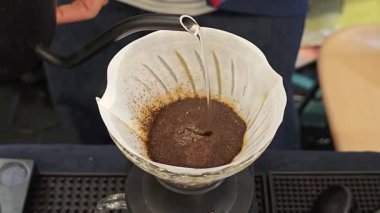  Sıcak su aromatik kahve telvelerinin üzerine yavaşça dökülüyor, zarif bir damlayla zengin dokusunu yakalıyor..