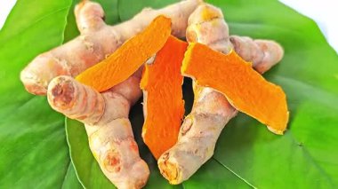 Taze zerdeçal kökleri ve canlı sarı dilimler, bu geleneksel bitkisel ilacın doğal rengini ve güçlü sağlık faydalarını sergiliyor..