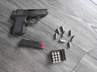 Küçük otomatik tabanca PSM 18 mm, koyu arkaplanda fişekler var..