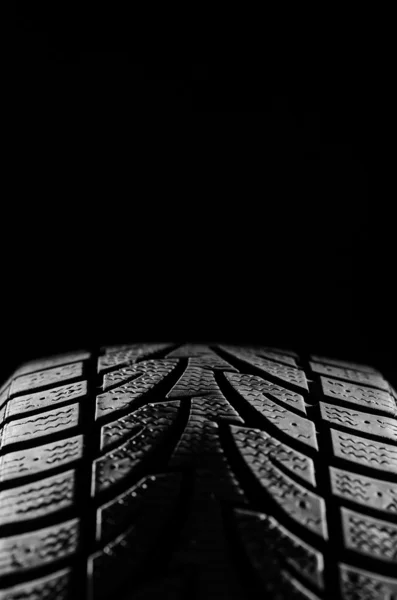 Black rubber tire on black — Stock Photo, Image