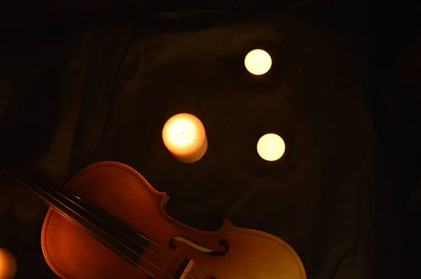 Group of burning candles and violin — Stock Photo, Image