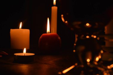 Bir grup yanan mum ve siyah arka planda sıcak şarap..