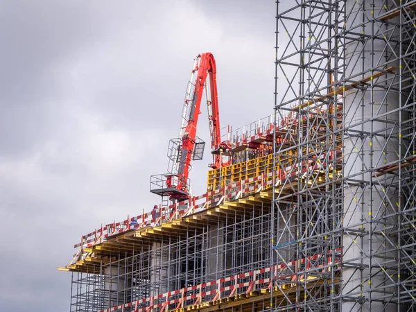 Concrete pump at a construction site. Construction of metal scaffolding at the construction of high-rise buildings