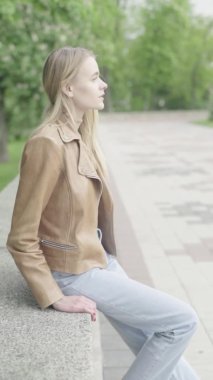 Parktaki genç, sıska bir kızın dikey videosu..