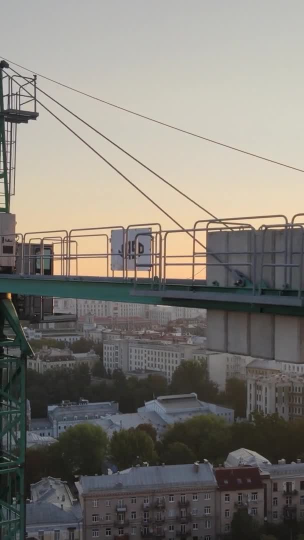 Vidéo verticale - Grue de chantier dans la ville au lever du soleil. Kiev, Ukraine. — Video