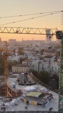 Dikey video - Şafakta şehirde inşaat vinci. Kyiv, Ukrayna.
