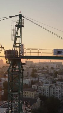 Dikey video - Şafakta şehirde inşaat vinci. Kyiv, Ukrayna.