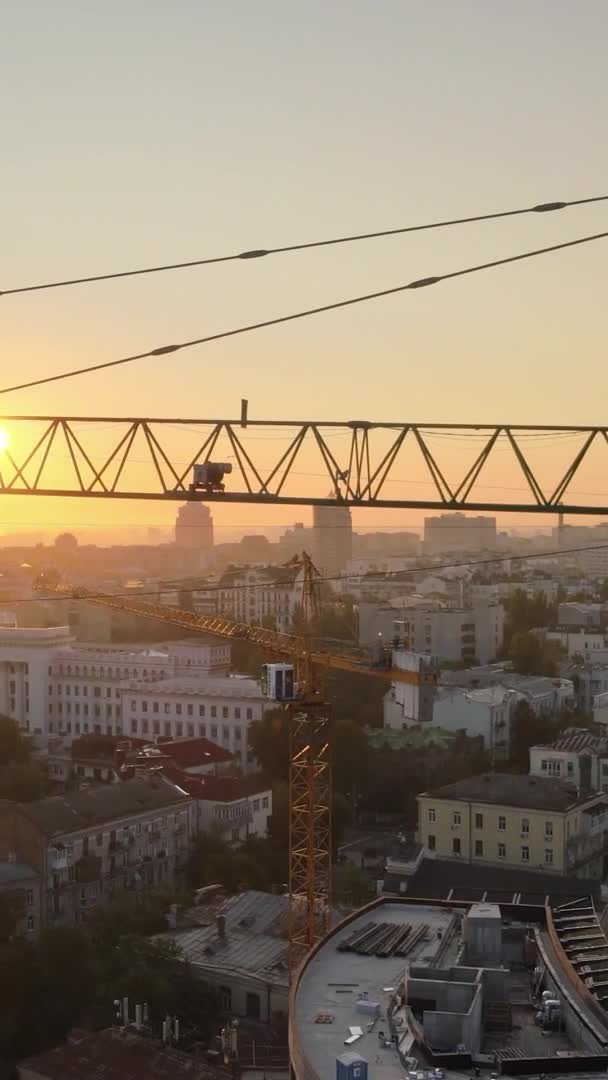 Vidéo verticale - Grue de chantier dans la ville au lever du soleil. Kiev, Ukraine. — Video