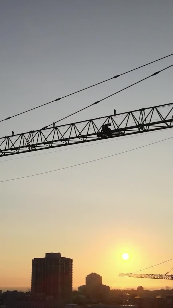 Verticale video - Bouwkraan in de stad bij zonsopgang. Kiev, Oekraïne. — Stockvideo