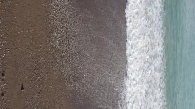 Sahile yakın bir yerde dikey bir deniz manzarası var. Kıyı sahili kıyılarına yakın çekim. Yavaş çekim