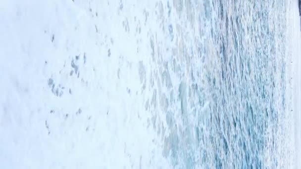 Vertikální video moře u pobřeží - detailní záběr na pobřežní pláň. Zpomalený pohyb — Stock video