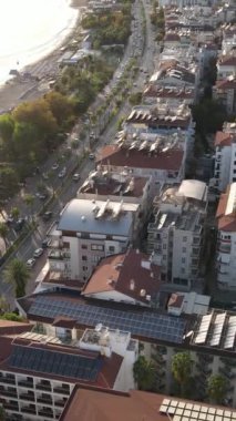 Dikey video Alanya, Türkiye - deniz kıyısında bir tatil köyü. Hava görünümü