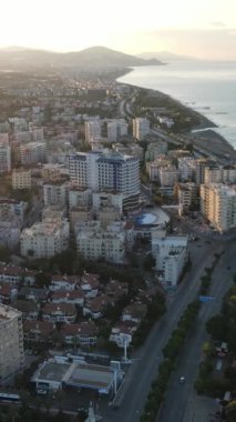 Dikey video Alanya, Türkiye - deniz kıyısında bir tatil köyü. Hava görünümü