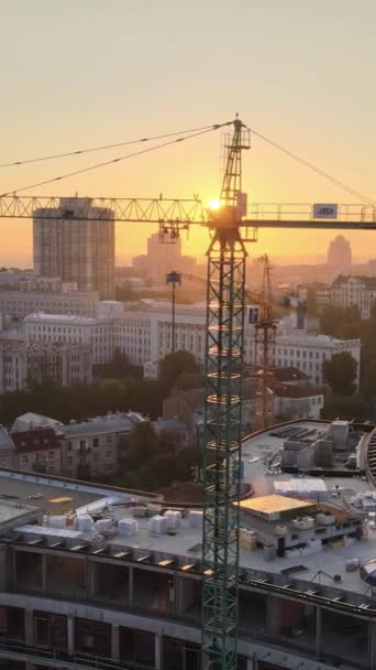 Строительный кран в городе на рассвете. Киев, Украина. Вертикальное видео — стоковое видео