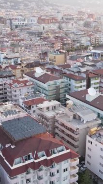 Dikey video Alanya, Türkiye - deniz kıyısında bir tatil köyü. Hava görünümü