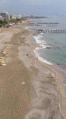 Dikey video Alanya, Türkiye - deniz kıyısında bir tatil köyü. Hava görünümü