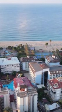 Dikey video Alanya, Türkiye - deniz kıyısında bir tatil köyü. Hava görünümü