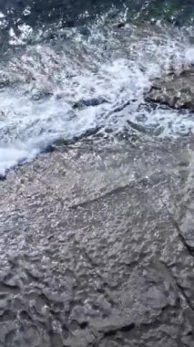 Sahile yakın bir yerde dikey bir deniz manzarası var. Kıyı sahili kıyılarına yakın çekim. Yavaş çekim