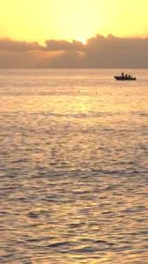 Deniz manzarası, deniz kıyısındaki güneş. Dikey video