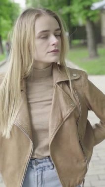 Parktaki genç, sıska bir kızın dikey videosu..