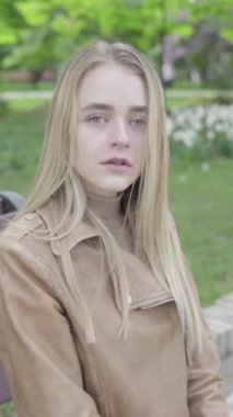 Parktaki genç, sıska bir kızın dikey videosu..