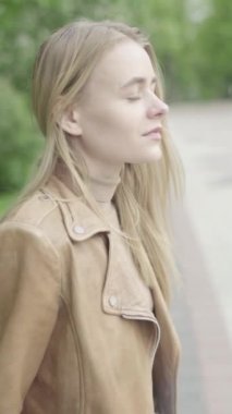 Parktaki genç, sıska bir kızın dikey videosu..