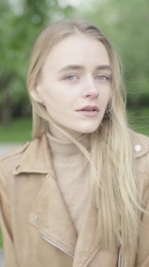 Parktaki genç, sıska bir kızın dikey videosu..