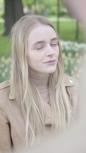 Vídeo vertical de una joven flaca en el parque. Chica hablando con alguien — Vídeos de Stock