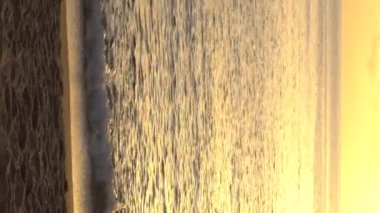 Deniz manzarası, deniz kıyısındaki güneş. Dikey video