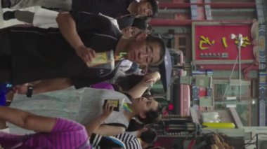 Şehrin sokaklarında bir grup insan var. Pekin 'de. Çin. Dikey video