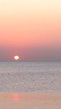 Deniz manzarası, deniz kıyısındaki güneş. Dikey video