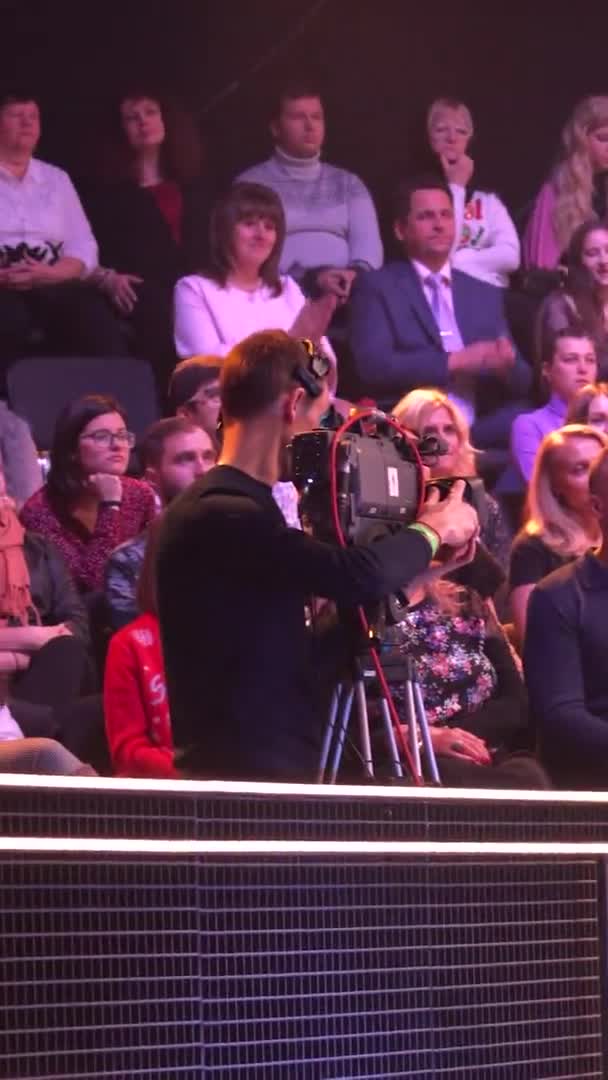 Mensen kijken in een tv-studio terwijl ze een tv-show opnemen. Verticale video — Stockvideo