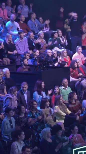 Mensen kijken in een tv-studio terwijl ze een tv-show opnemen. Verticale video — Stockvideo