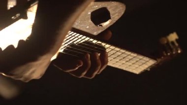 Erkek gitarist, karanlıkta gitar çalar. Dikey video