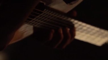 Erkek gitarist, karanlıkta gitar çalar. Dikey video