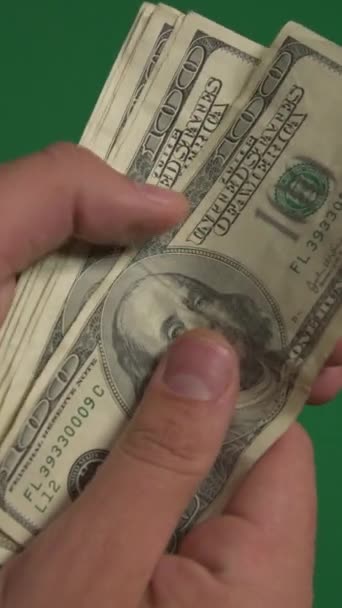 Долларов. Американские деньги крупным планом на зеленом фоне хромаки. Вертикальное видео — стоковое видео