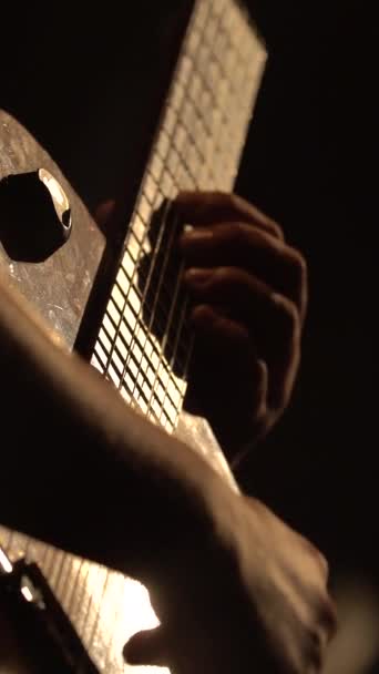 Le guitariste masculin joue de la guitare dans le noir. Vidéo verticale — Video