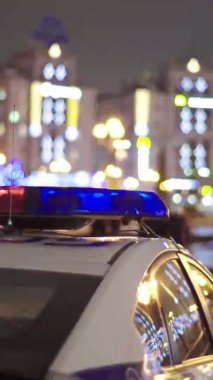 Gece bir polis arabasının çatısında teşhirci. Dikey video.