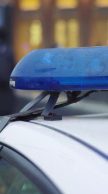 Gece bir polis arabasının çatısında teşhirci. Dikey video.