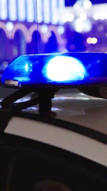 Gece bir polis arabasının çatısında teşhirci. Dikey video.