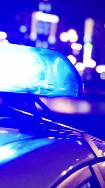 Gece bir polis arabasının çatısında teşhirci. Dikey video.