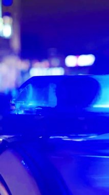 Gece bir polis arabasının çatısında teşhirci. Dikey video.