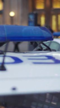 Gece bir polis arabasının çatısında teşhirci. Dikey video.