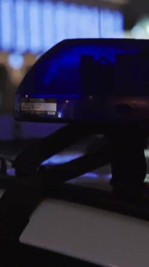 Gece bir polis arabasının çatısında teşhirci. Dikey video.