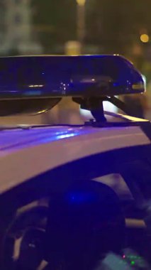 Gece bir polis arabasının çatısında teşhirci. Dikey video.