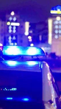 Gece bir polis arabasının çatısında teşhirci. Dikey video.