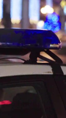 Gece bir polis arabasının çatısında teşhirci. Dikey video.